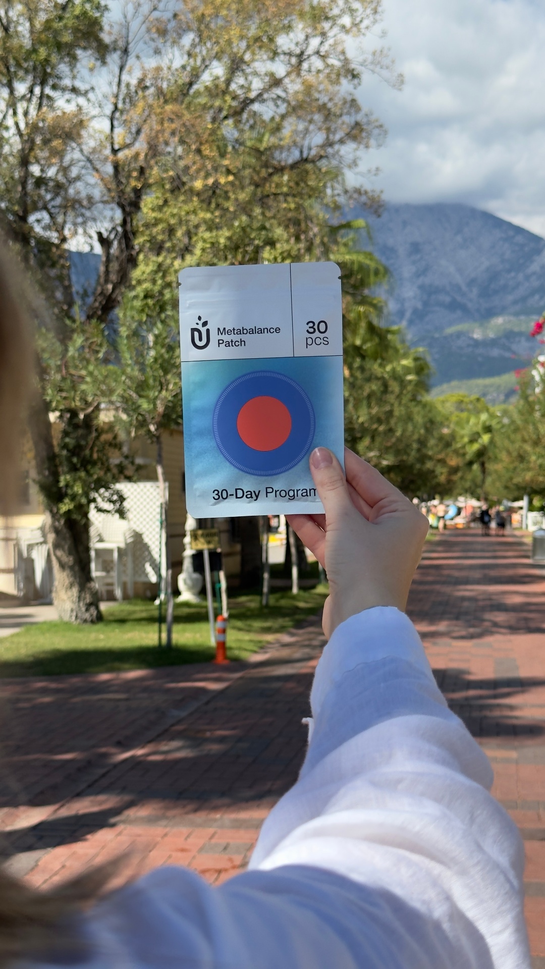 Hand holding the 30-day Metabalance Patch program outdoors